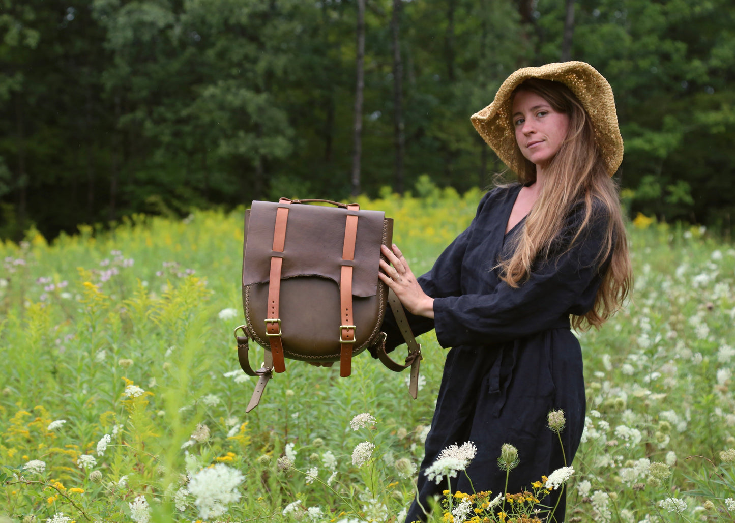 Crystal Van Gaasbeck of Under the Tree Farm, with a leather backpack she made. The backpack is for sale online